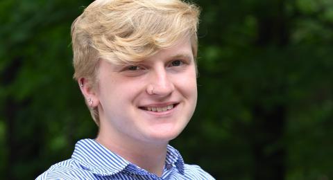 McNair scholar, professionally dressed, smiling, wooded backdrop