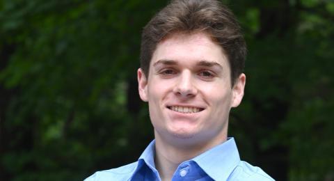 McNair scholar, professionally dressed, smiling, male, wooded backdrop